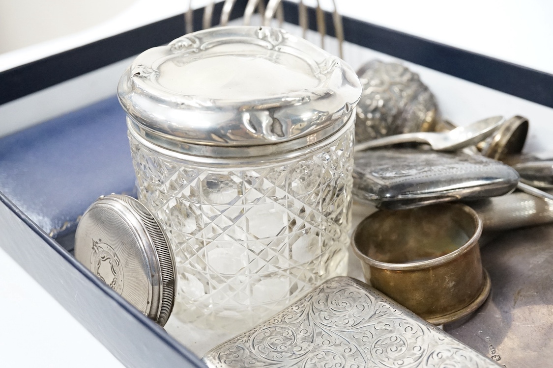 A group of small silver including a George V capstan inkwell, Birmingham, 1924, base diameter 14cm, two cigarette cases, a vesta case, a five bar toast rack, a commemorative dish, mounted glass toilet jar, a matchbook ca
